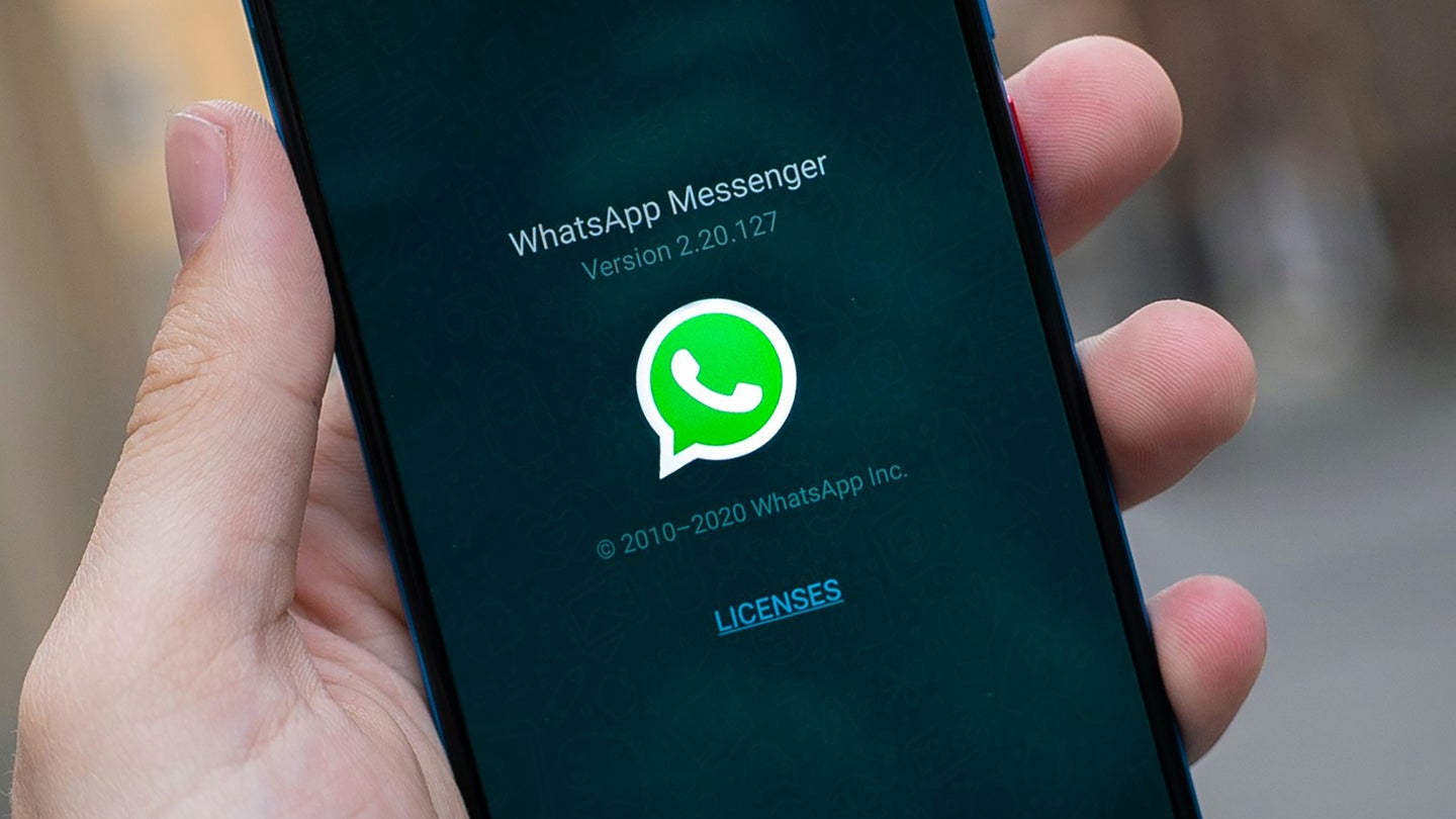 Hand holding phone with WhatsApp open. WhatsApp will help you move your messages between phones.